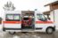 Two paramedics sitting in an ambulance parked outside on a snowy day.